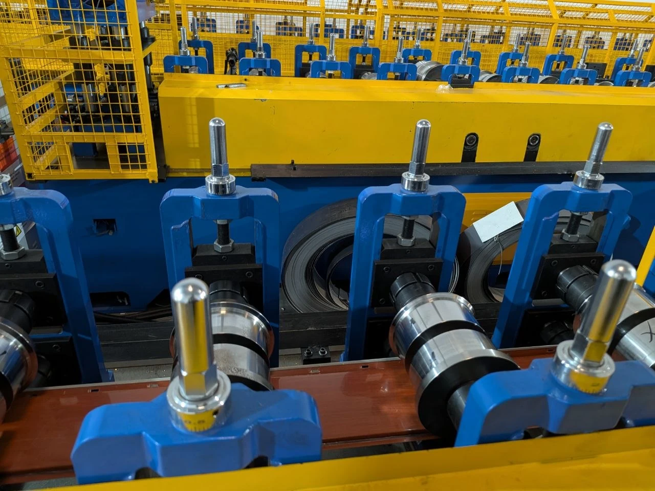 Blue roller stations and yellow safety guards on a Terrashield roll-forming line